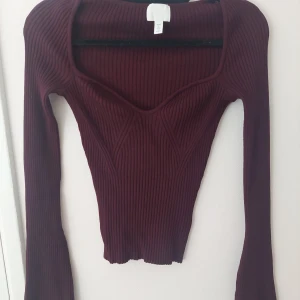 Vinröd ribbad topp - Vinröd figurnära ribbad topp från HM. I gott skick och säljer pga att den inte kommer till användning. 