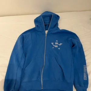 Blå hoodie Junkyard x Starr Games XS - Blå zip hoodie från Junkyard. Nästan aldrig använd men säljer eftersom den inte riktigt är min stil längre. Orginalpris 799kr. Det är bara att kontakta mig om ni har några frågor🩷