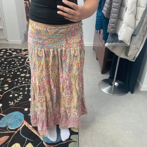 Färgglad långkjol - Jättefin mönstrad  långkjol i tunt material. Kjolen är i one size storlek men har stretchig midja och passar bra på mig som brukar ha storlek S. 