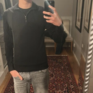 Svart långärmad half zip tröja - Säljer denna stilrena zip tröjan. 100% merino ull som är jätte skönt. Priset står inte skrivet i sten!!