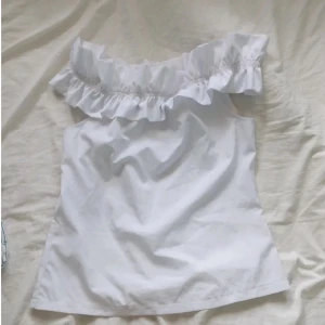 Vit offshoulder topp med volang - Säljer en söt vit offshoulder topp med volangdetaljer. Storlek S, men lite liten i storleken så passar en S/XS! Fint skick!💖