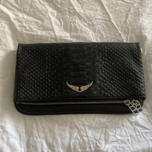 Svart Zadig & Voltaire väska - Säljer en svart axelväska från Zadig & Voltaire, säljer för att jag inte har fått någon användning för väskan💗detaljerna är i silver & det finns tyvärr inget mindre extra band till!!💗