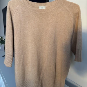 Beige kashmirtröja från Jackie - Säljer en stilren beige kashmirtröja från Jackie. Tröjan har trekvartsärmar och en rund halsringning med ribbade detaljer. Perfekt för en avslappnad och elegant look.