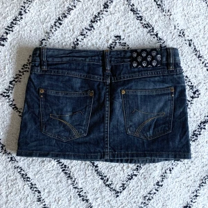 Kort jeanskjol - Jättefin mörkblå kjol i storlek 26, färgen stämmer bäst överens med bilderna med kjolen på  Midja: 39  Längd: ca 30