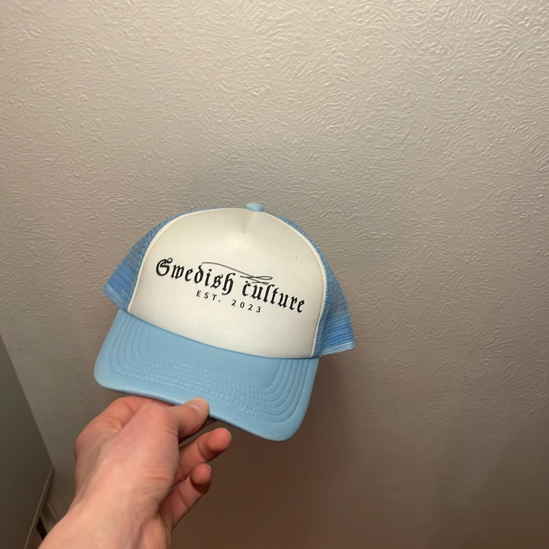 Ljusblå och vit keps med text - 2