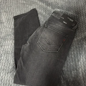 Svarta jeans från Replay - Snygga mörk gråa jeans från Replay med klassisk femficksdesign. De har en stilren look med en mörk tvätt och är perfekta för en avslappnad stil. Passar bra till både t-shirt och skjorta. Använd två gånger, säljs då de blev för små för min bror. 