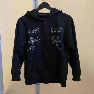 Bling lucid hoodie - Säljer en bling lucid klassisk design med dragkedja och fickor med en snyggt tryck gjort av pärlor!