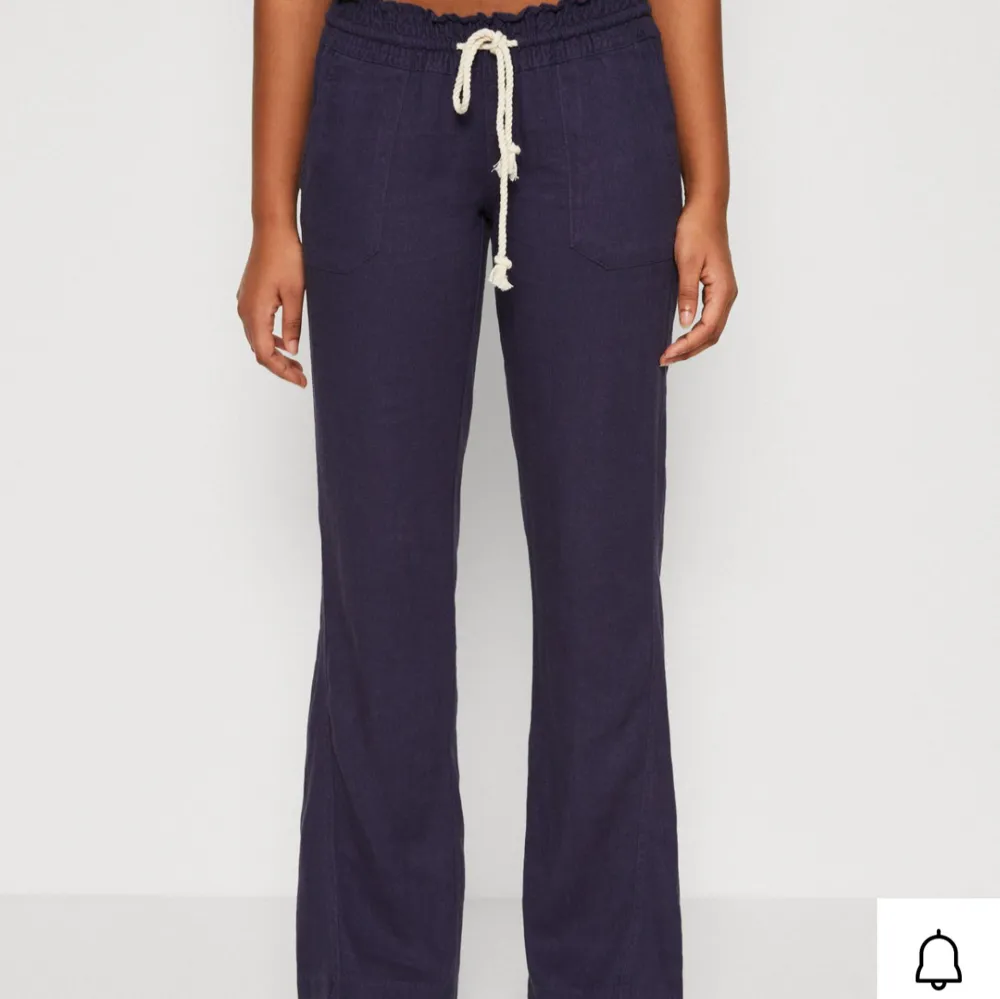 Snygga mörkblå linnebyxor med avslappnad passform och snörning i midjan. Perfekta för en casual look. Byxorna har en rak stil och är tillverkade i ett mjukt material för extra komfort 💞 De är ifrån roxy och köpta på zalando för 600kr. Farkut & Housut.