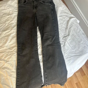 Grå jeans från Perfect Jeans Gina Tricot - Snygga grå/ svarta bootcut jeans från Perfect Jeans i storlek 38. Medel midja. Snygg slits och liten ”sliten” model vid bensluten. Den perfekta bootcut jeansen!!! 