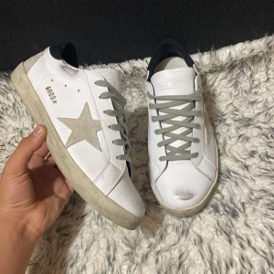 Golden Goose Superstar sneakers vit/grå - Golden Goose Superstar sneakers i vitt skinn. Fick dessa skor som en present och säljer dem då dem var lite för småa för mig riktig bra skick nytt skick använt en gång skriv gärna vid funderingar så svarar jag inom kort 😉