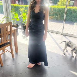 Mörkblå långklänning med öppen rygg - Säljer en elegant mörkblå långklänning/balklänning. Har använt den en gång på balen så den är i nyskick. Den är i storlek XS