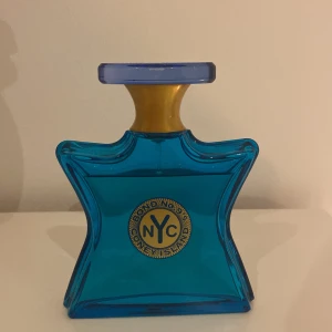 Bond No. 9 Coney Island parfym - Unik parfymflaska från Bond No. 9 i modellen Coney Island. Flaskan är stjärnformad i klarblått glas med gulddetaljer och blått lock. Perfekt för dig som gillar exklusiva och färgstarka dofter med en cool NYC-vibe.