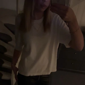 Vit t-shirt från Vero Moda - En basic vit t-shirt från Vero Moda med rund hals och korta ärmar. Modellen är något boxig och har en avslappnad passform. Perfekt att matcha med jeans eller kjol för en clean look. Tillverkad i mjuk bomull som känns skön mot huden.