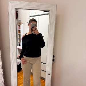 Svart offshoulder långärmad tröja - Svart långärmad tröja med offshoulder-design och en cool axelrem som ger en asymmetrisk look. Tröjan är i mjuk bomull och har en normal passform. Perfekt för dig som gillar stilrena plagg med en twist.