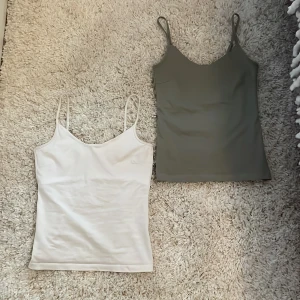 2-pack linnen från 157, vit & grön - Två stilrena linnen från 157 i storlek S, ett i vitt och ett i olivgrönt. Båda har smala axelband och rak passform. Materialet är mjuk bomull med lite stretch för extra komfort. 