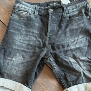 Svarta jeansshorts från Jack & Jones XS - Snygga svarta jeansshorts från Jack & Jones i storlek XS. De har klassisk femficksdesign, uppvikta benslut och en cool tvättad look. Perfekta för en avslappnad stil under varma dagar.