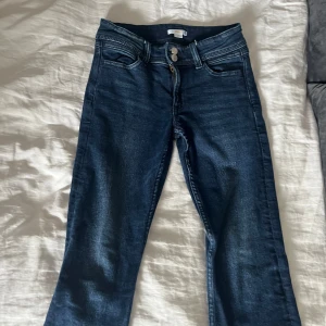 Mörkblå jeans från Gina Tricot - Snygga low Rise bootcut jeans från Gina Tricot i storlek 158. Använda ett par få gånger och i ettt jättebra skick.
