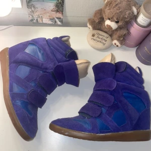 Isabel Marant skor  - Pris: 2700 kr  Säljer dessa sjukt snygga Isabel Marant skor i lila/blå 💜 Dom är i storlek 37 och har en inbyggd klack så man blir ungefär 4cm längre men ändå sköna att gå i 😍  Lite grå inuti men inget man märker när man har dom på, annars i jättefint skick! Går typ inte att hitta längre i den här färgen så passa på 🤗  💌 Skriv om du vill ha fler bilder eller har frågor!