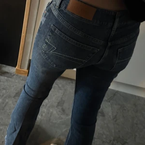 Blå jeans från Junkyard XS - Snygga blå jeans från Junkyard i klassisk femficksmodell. Jeansen har kontrastsömmar, normalhög midja och raka ben med lätt tvättad look. Bakfickorna har en cool broderad detalj och läderpatch med logga. Low waist bootcut. Nypris 599kr. Aldrig använda då ja köpte fel färg💞