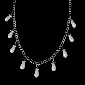 Silverhalsband med droppformade pärlor - Kedjehalsband i silverfärg med nio droppformade vita pärlor som hänger längs hela kedjan. Pärlorna har en snygg glans och ger halsbandet en cool och elegant vibe. Rostfritt stål.