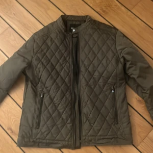 Olivgrön field jacka - Snygg olivgrön field jacka jacka i toppskick från MERLEY. Jackan har ett rutigt/quiltad mönster. Perfekt nu inför hösten 👍orginalpriset var 749kr. Kontakta mig om du har några frågor 😊
