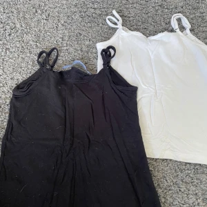 2-pack linnen med spets XS Black Label - Två linnen i storlek XS från The Black Label Collection. Ett svart och ett vitt, båda med smala axelband och fin spetskant upptill. Perfekta att styla lager på lager eller till jeans. Mjukt bomullsmaterial som känns skönt mot huden.