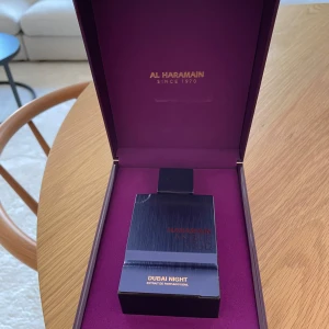Al Haramain Dubai Night Eau de Parfum - Exklusiv parfym från Al Haramain i doften Dubai Night. Flaskan är mörklila med en elegant, fyrkantig form och svart lock. Kommer i en lyxig lila ask med gulddetaljer. Perfekt för dig som vill ha en unik och orientalisk doftupplevelse.