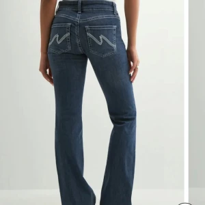 Nellys Low Waist Bootcut Stitch Jeans - Lågmidkade jeans från Nelly med detaljer på bakfickorna. De heter ”Low Waist Bootcut Stitch Jeans”. Skriv för egna bilder. 