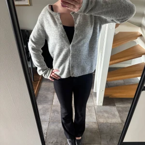 Ljusgrå stickad kofta -  ljusgrå stickad kofta med rund hals och knäppning framtill. Koftan har långa ärmar och en rak passform. nypris 150kr