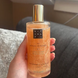 Rituals The Ritual of Karma Soul Shimmering Body Oil - Lyxig kroppsolja med skimrande effekt från Rituals, The Ritual of Karma. Oljan har en gyllene, glittrig färg och kommer i en genomskinlig flaska med guldfärgat lock. Perfekt för att ge huden en vacker lyster. Den är helt ny där av priset men de går att diskutera 💞💞
