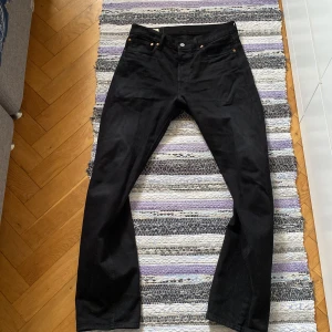 Svarta Levi's 501 jeans - Klassiska svarta Levi's 501 jeans. Jeansen är i bra skick, inga skador och ytterst lite tecken på användning, dvs. att färgen har bleknat vid exempelvis bakfickor.
