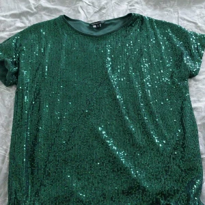 Grön paljetttröja - Säljer en grön t-shirt med paljetter i storlek M från New Yorker. Endast använd en gång under en temadag i skolan🌸