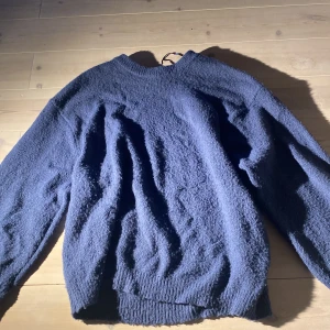 Mörkblå fleece-tröja från 157 - Mysig mörkblå fleece-tröja från 157 med rund halsringning och ribbade muddar. Perfekt för kyliga dagar och enkel att matcha med andra plagg. Tröjan har en avslappnad passform och är superbekväm.