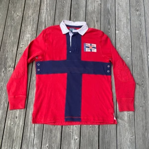 Röd pikétröja från Polo Ralph Lauren - Rare Vintage Ralph Lauren rugbytröja i mycket bra skick! Tröjan är i storlek M och passar ungefär 177-184 beroende på hur man vill att den ska sitta! Man kan ofta hitta den här tröjan för uppemot 1000:- på bland annat eBay så detta är ett kap! Hör aver om frågor!