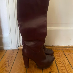 Vinröda/ lila höga stövlar med klack och dragkedja - Garderobsrensning pågår! 👗 Shoppa loss bland en massa fina plagg. Kika in på min sida, så kanske du hittar något mer du gillar!  Har du frågor om ett plagg? Tveka inte att höra av dig!  (OBS: Kan tyvärr inte ta bilder med plaggen på.)