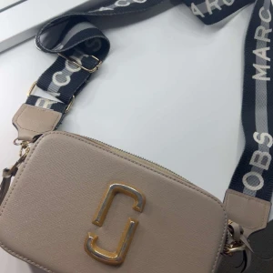 Beige axelväska  - Säljer en beige axelväska. Väskan har guldfärgade metalldetaljer och dragkedja upptill. Den saknar en del färg men man kan lätt fixa det själv om man köper guld färg ❤️priset kan diskuteras