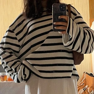 Vit och svart randig stickad tröja - Jättemysig vit stickade tröja med en avslappnad passform, storlek xl men passar mest xs-s skulle jag säga