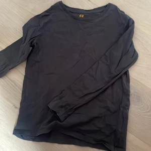 Svart långärmad tröja från H&M - En enkel svart långärmad tröja från H&M Basic, tillverkad i ekologisk bomull. Perfekt basplagg med rund halsringning och mjukt material. Passar till många olika outfits.
