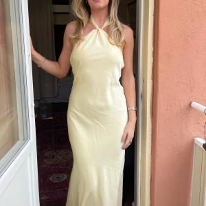 Balklänning  - Vacker ljusgul balklänning i satin med låg rygg, köpt på plick och bara använt 1 gång🤍är 175 och bra i längden på mig