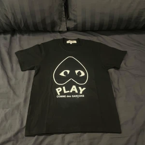 Svart t-shirt från Comme des Garçons Play - En riktig snygg T-shirt från Comme des Garçons. | Den passar som en vanlig T-shirt. Den passar mig som är 170cm och den passar om man är där omkring i längden. | Det är bara att höra av sig om man har några frågor eller vill ha flera bilder.