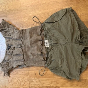 Grön y2k top  Urban Outfitters - Supersöt grön topp från Urban Outfitters med volangdetaljer och knyt framtill. Korta ärmar och är suuuperskön när det är varmt ute. Perfekt att styla med shorts eller kjol!