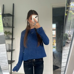 Blå stickad tröja - Säljer en blå stickad tröja med lång ärm och rak passform från Asos. Tröjan är enkel i designen och har en något croppad längd som svänger något utåt, perfekt till typ jeans. Mjukt materialll