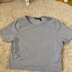 Ljuslila croppad t-shirt från ASOS  - Säljer en ljuslila croppad t-shirt från ASOS DESIGN. T-shirten har rund halsringning och korta ärmar. Perfekt att matcha med jeans eller kjol för en avslappnad look.