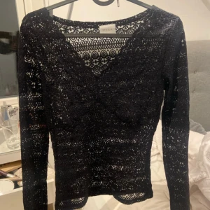 Svart spetstopp  - en svart långärmad spetsblus från Vero Moda. 