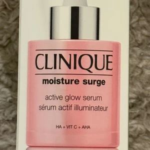 Clinique Moisture Surge Active Glow Serum 30 ml  - Clinique Moisture Surge Active Glow Serum med HA, vitamin C och AHA. För en strålande och återfuktad hud. Flaskan är rosa med silverdetaljer och innehåller 30 ml. Ny & Oöppnad. Nypris 545 kr. 
