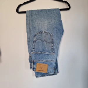  Jack & Jones jeans - Säljer ett par klassiska blå jeans från Jack & Jones. De har en rak passform och är tillverkade i denim med en ljus tvätt. Perfekta för en avslappnad stil.                  W27 och L30