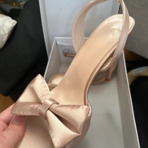 Beige sandaletter med rosett - Eleganta beige sandaler med öppen tå och en fin rosett på framsidan. Dom är helt oanvända, tro till storlek och väldigt sköna.