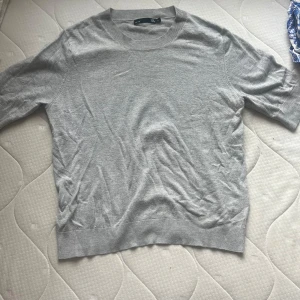 Grå stickad T-shirt  - Grå stickad T-shirt i mjukt material med resor i kanterna. Sparsamtanvänd i storlek s. Bara att skriva om du har någon fråga!💗