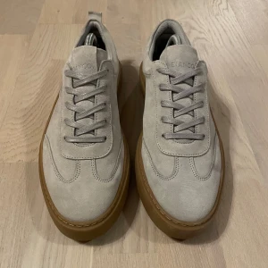 BIANCO mocka skor Clarks - Snygga, sköna grå/beiga mocka sneakers från märket Bianco. Skorna är storlek EU 43 och liknar Maison Margiela skor. Dessa skor har en ljusbrun sula i kvalitets gummi och fin mocka. Dom är i mycket bra skick använda vid 3 tillfällen. Mycket fina skor, rekommenderar dessa! Hör av er vid frågor!🔥🤝