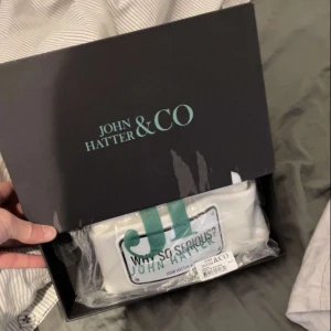 Vite John Hatter mössa  - En sprillans helt ny John hatter mössa som aldrig kommit i användning varm och skön mössa skriv för funderingar eller frågor